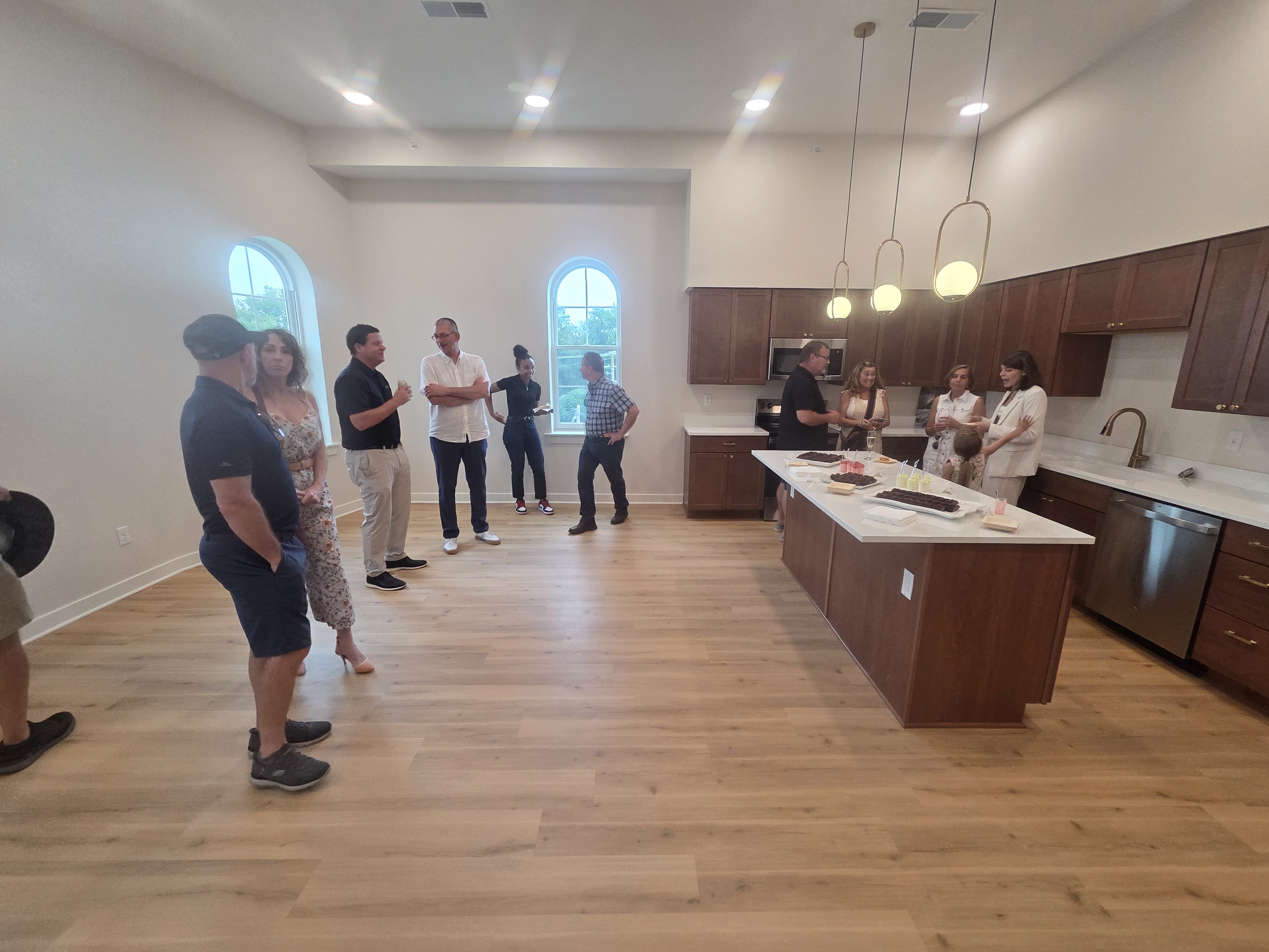 Guests gathering around Fetch’s food spread in an apartment kitchen.