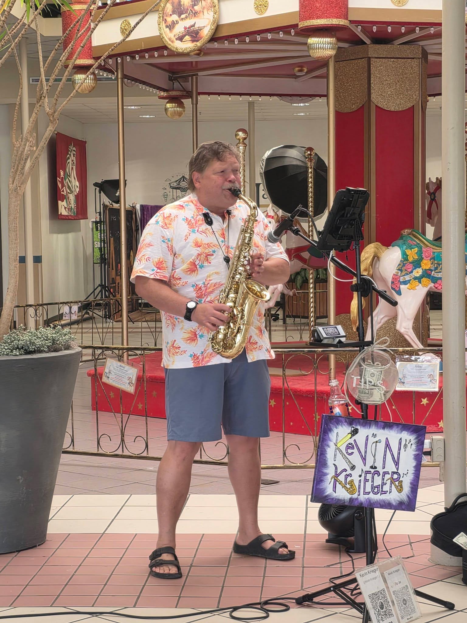 A saxophonist performing live beside the carousel