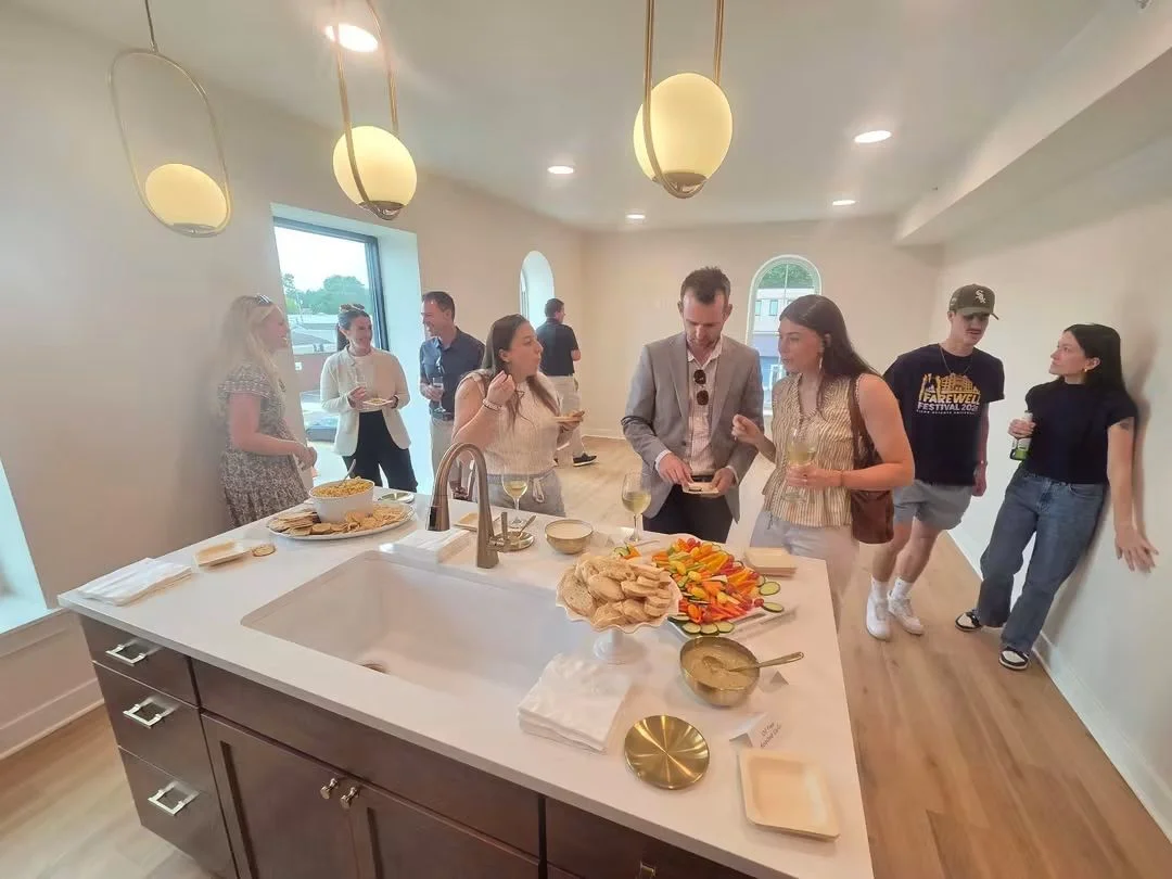 Guests chatting and sampling food around the kitchen island.