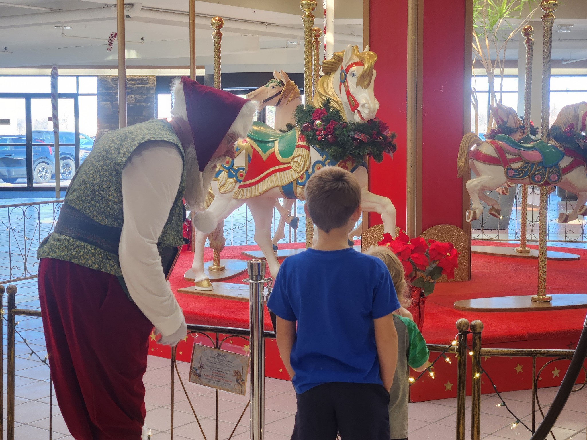 A holiday character greeting children beside the carousel at Jackson Crossing